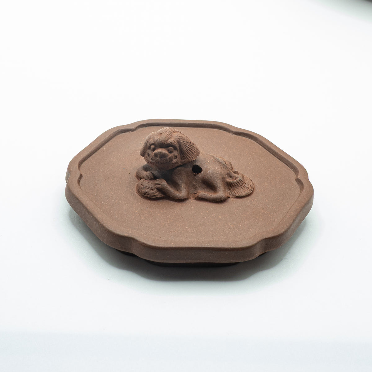 Close-up view of a vintage Factory 1 Yixing Zisha clay teapot lid featuring a hand-sculpted resting lion finial with a central air vent hole.