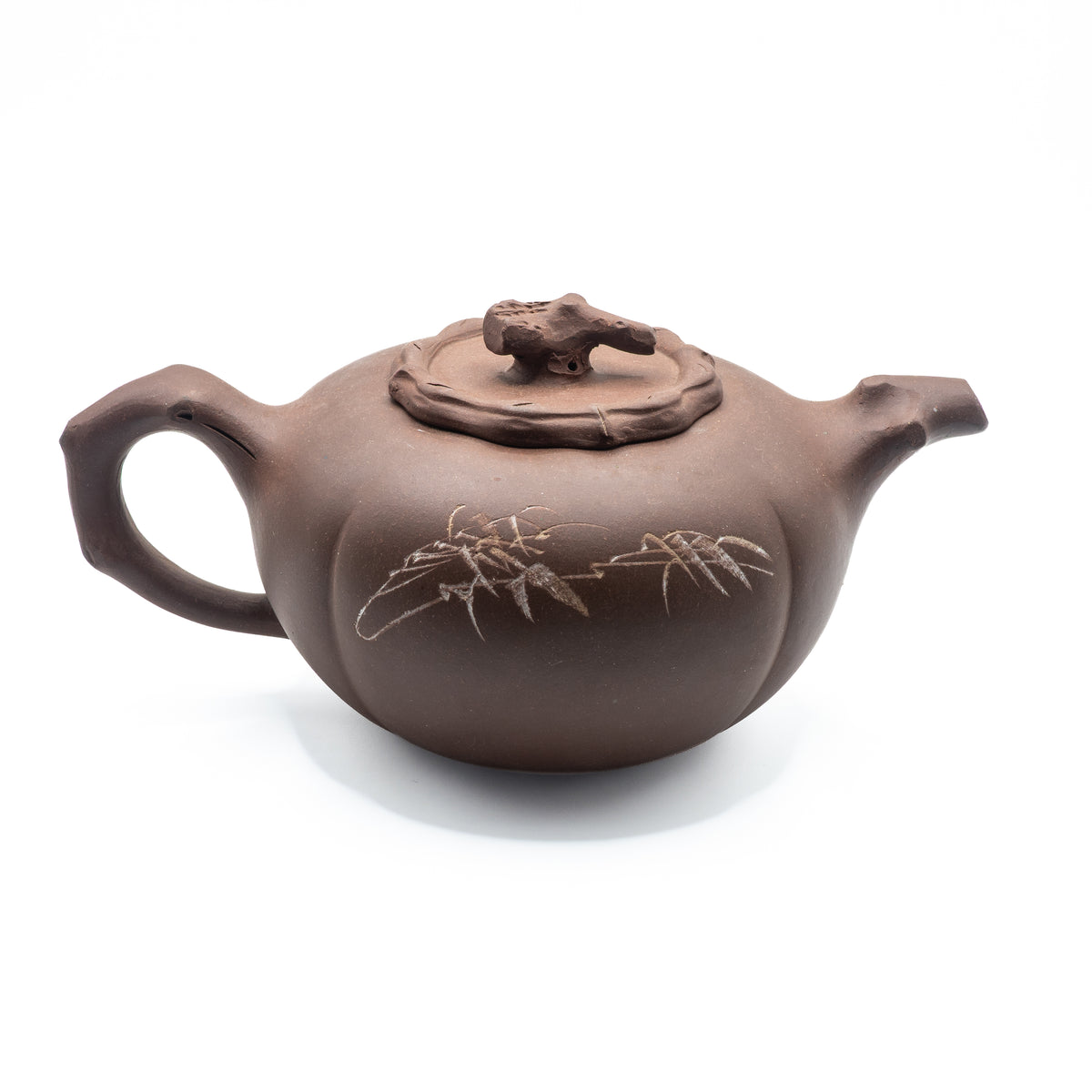 Reverse view of a vintage Factory 1 Yixing Zisha clay segmented teapot showing a hand-engraved bamboo branch motif and a sculpted pine wood bark style handle.