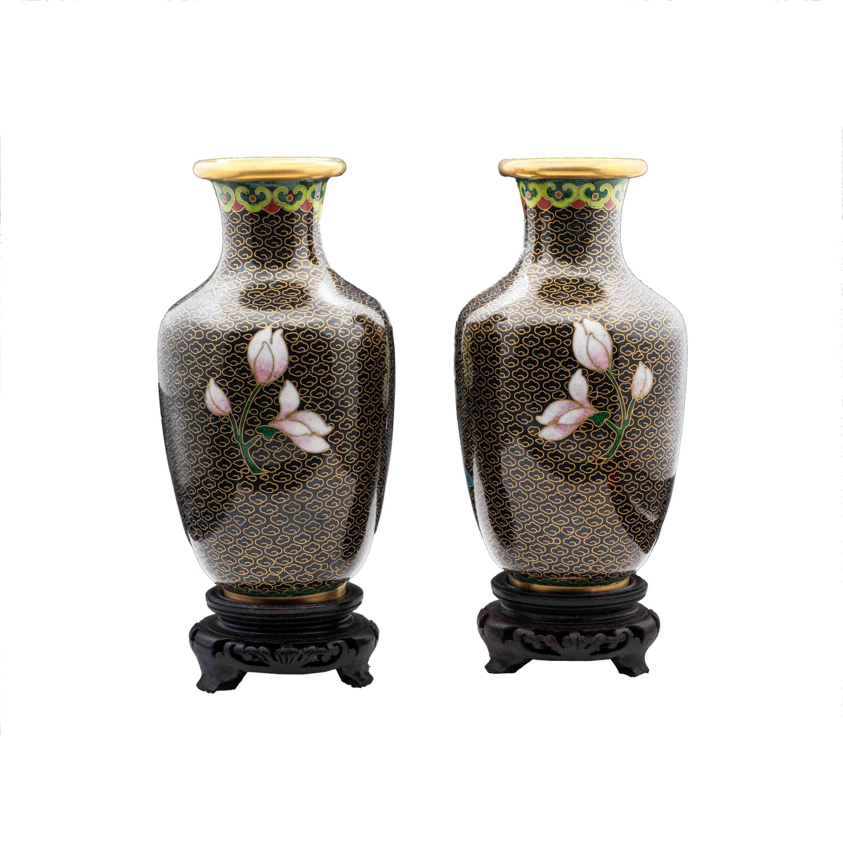 A pair of vintage cloisonné baluster vases showing the reverse side hand-enamelled white magnolia flower blossoms over a black cloud ground on carved wooden pedestals.