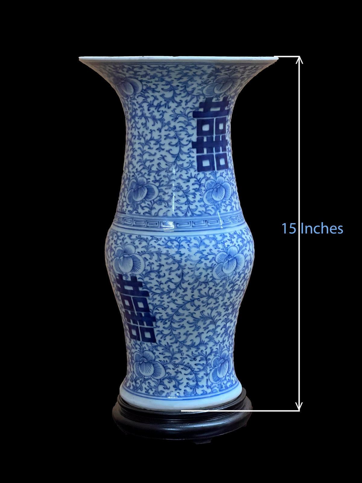 A blue and white porcelain vase featuring a double happiness character and intricate floral vine patterns. The vase stands on a dark wooden base and includes a measurement indicator showing a total height of 38.1 cm without stand.