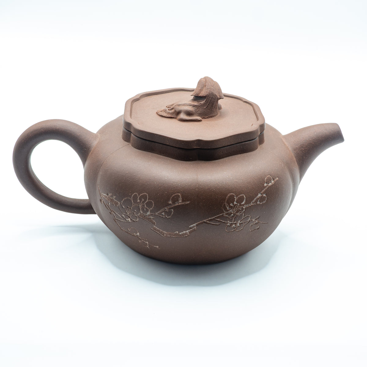 Reverse view of a vintage Factory 1 Yixing Zisha clay teapot showing a hand-engraved plum blossom branch motif and a sculpted resting lion lid finial.