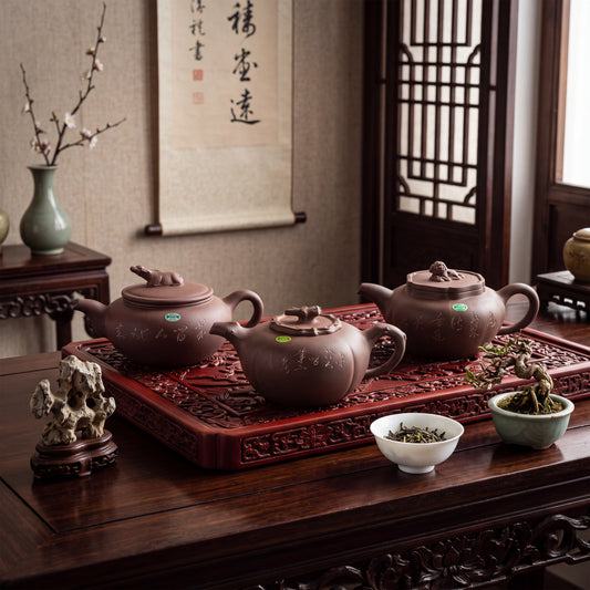 Three dark brown zisha clay teapots with rounded bodies and lids, each featuring a small sculpted animal figure on top. The teapots are decorated with engraved Chinese characters and are arranged on a rectangular carved wooden tray.