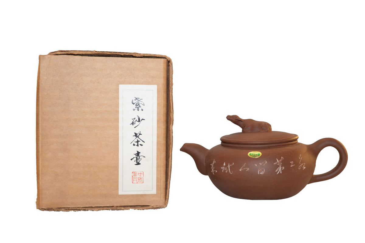 Vintage Factory 1 Yixing Zisha clay water buffalo teapot shown side-by-side with its original rare brown cardboard shipping box featuring a vertical white calligraphy label.