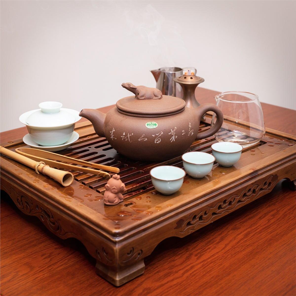 Vintage Factory 1 Yixing Zisha clay water buffalo teapot arranged on a traditional carved wooden tea tray during a classical Gongfu tea ceremony service.