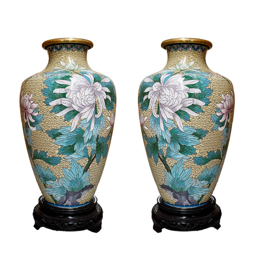 A pair of vintage Chinese cloisonne baluster vases featuring hand-enameled white spider chrysanthemums over a cream yellow cloud pattern ground on carved wooden pedestals.