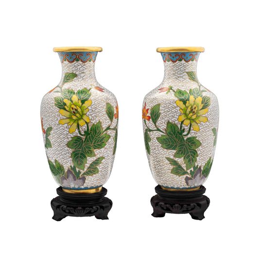 A pair of vintage cloisonné baluster vases featuring hand-enamelled yellow chrysanthemum flowers over a white cloud ground on carved dark wood display pedestals